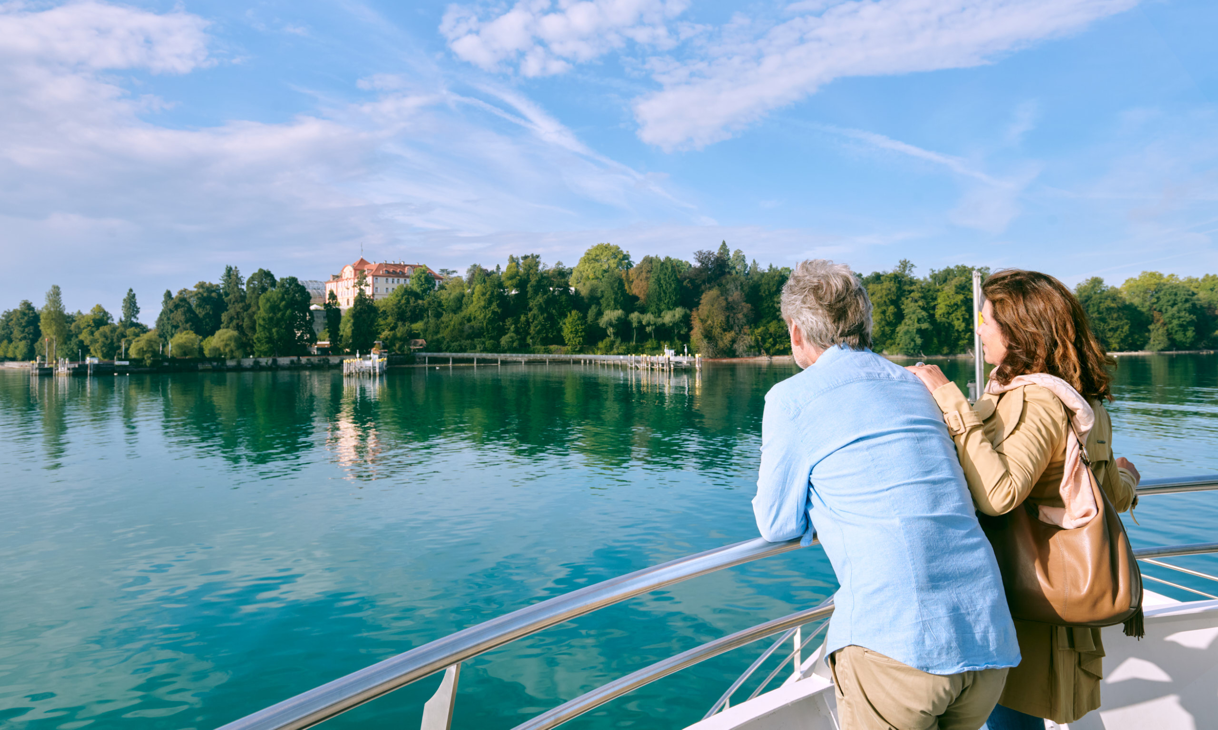 Insel Mainau / Bjørn Jansen Ein Paar reist mit dem Schiff auf die Insel Mainau und blickt auf den Mainau Hafen vom Schiff aus
