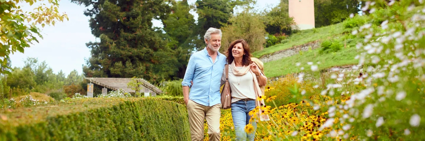 Ein Mann und eine Frau spazieren durch den Staudengarten auf der Insel Mainau