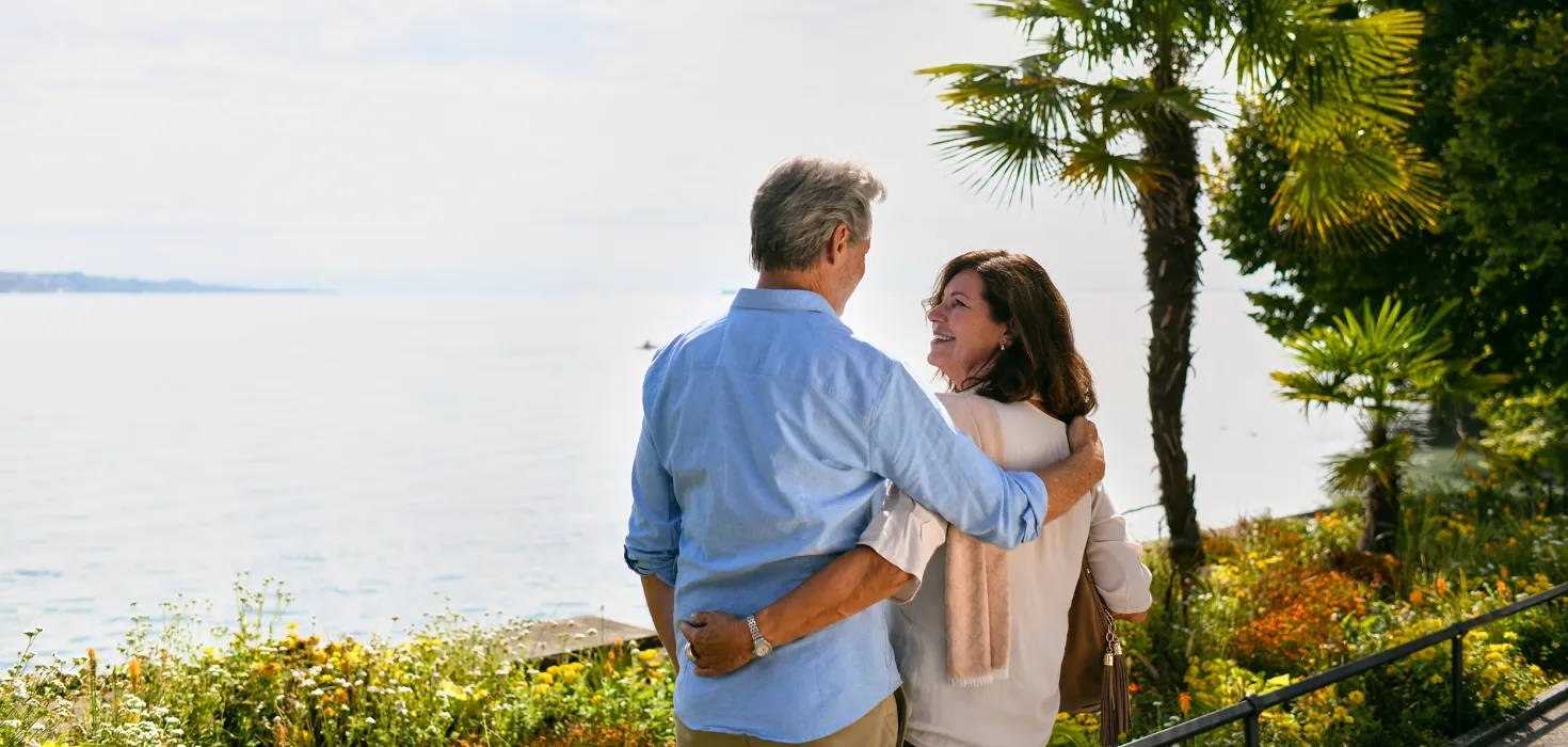 Ein Mann und eine Frau blicken auf den Bodensee im Sonnenschein