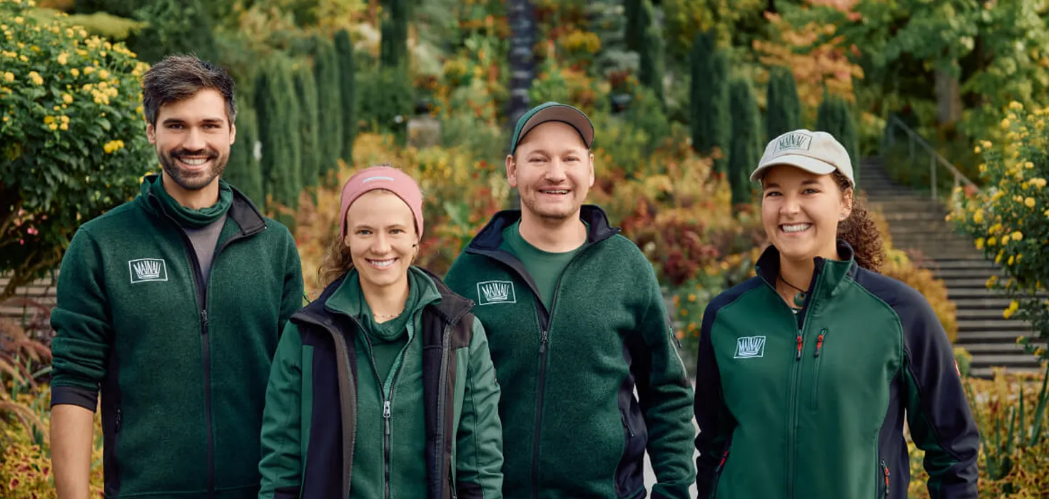 Gartenkompetenz auf der Insel Mainau – das Gärtnerteam im Einsatz für blühende Vielfalt Team der Gärtnerinnen und Gärtner der Insel Mainau in Arbeitskleidung, umgeben von blühender Gartenpracht – stellvertretend für fachkundige Gartenpflege und grüne Kompetenz.