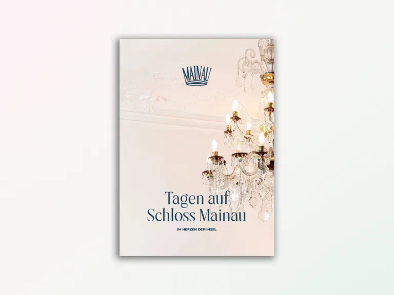 Titelbild mit Kronleuchter in einem eleganten Raum und dem Schriftzug ‚Tagen auf Schloss Mainau – Im Herzen der Insel‘ unter dem Mainau-Logo