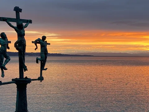 Schwedenkreuz vor einem ruhigen See bei Sonnenuntergang