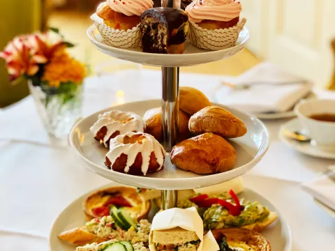 Etagere mit kleinen Kuchen und Sandwiches