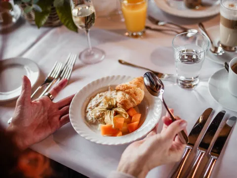 Brunch im Herbst Ein gedeckter Tisch mit Herbstblumen, Sektgläsern und Orangensaft sowie einem Frühstückscroissant