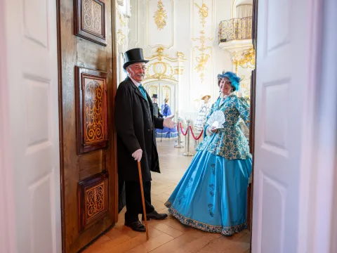 Insel Mainau / Rainer M. Hohnhaus Zwei historisch gekleidete Personen öffnen die Türen zu einem herrschaftlichen Saal