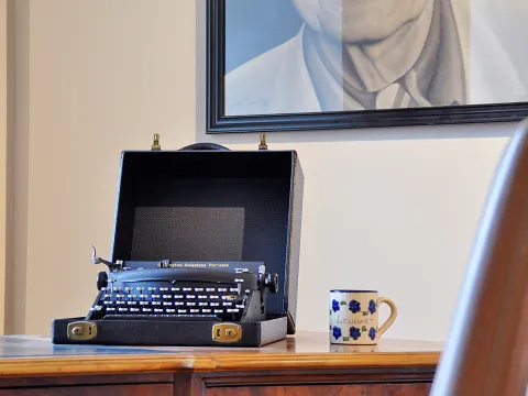 Eine Schreibmaschine auf einem Tisch, daneben eine Tasse, auf der Lennart steht