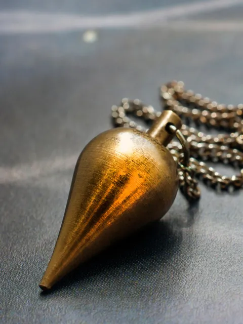 Mainau Akademie / AdobeStock Goldenes Pendel an Kette