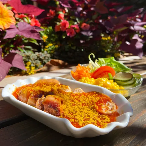 Currywurst und Salat an bepflanzten Tischen Würstle Grill Insel Mainau